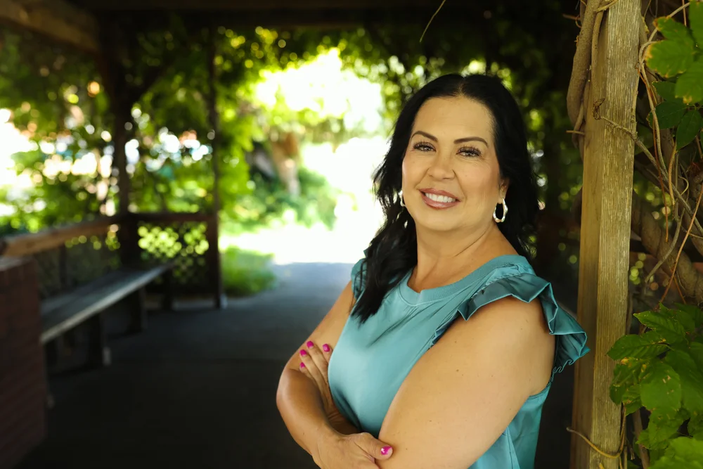 Tracy Sanchez outdoors in a teal blouse